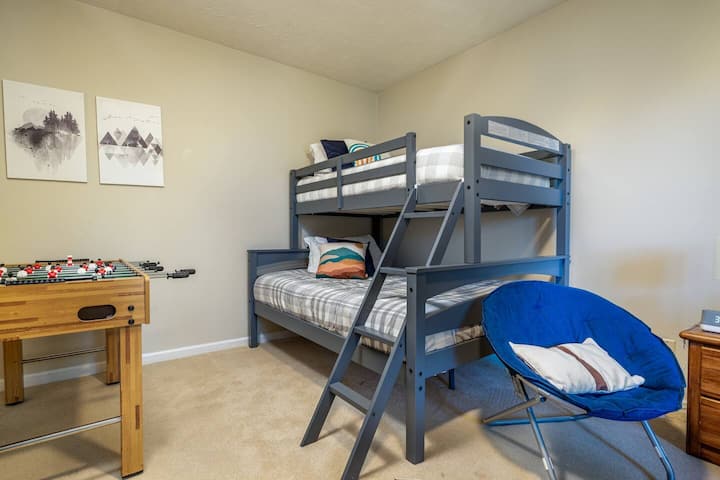 Twin-over-full bunk room, also featuring a football table and sitting area around big-screen TV.   