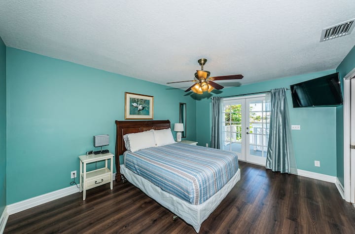 ห้องนอนพร้อมระเบียงส่วนตัวและพัดลมเพดาน