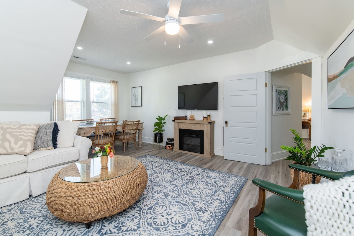 Experience the warmth of a fireplace and the charm of a dining area seamlessly integrated into a cozy living room where comfort and style converge in perfect harmony.