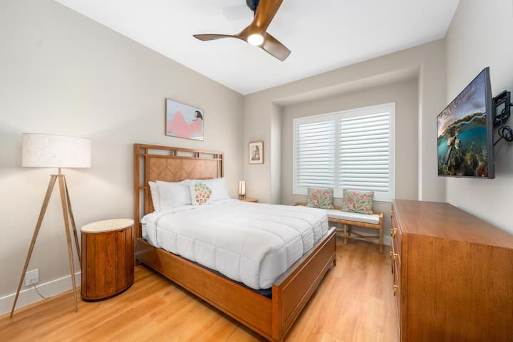 - 舒适的客房，配备木制床架和配套的边桌，外观和谐 - 大窗户配百叶窗，既能带来自然光线，又能保护隐私 - 装饰性枕头和长凳座椅为温馨的空间增添了舒适感和时尚感