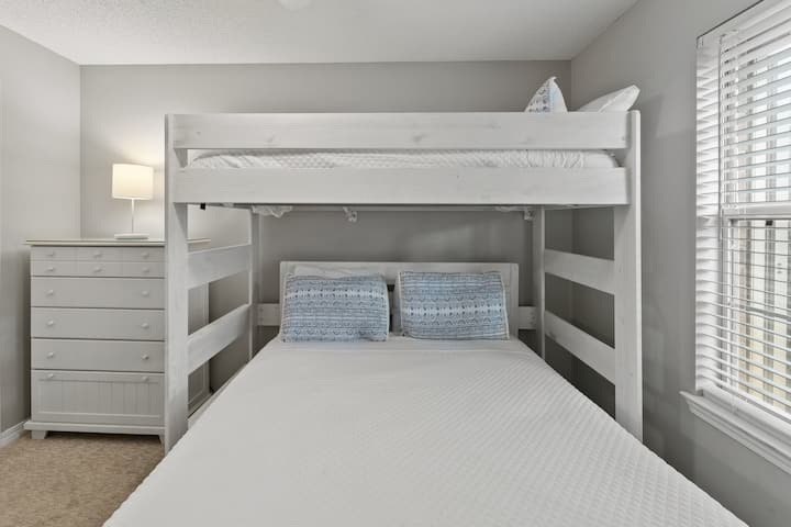 Chumba chenye starehe cha ghorofa chenye kitanda cha mapacha, mashuka safi na rangi nzuri—nzuri kwa watoto au mipangilio ya kulala inayoweza kubadilika.