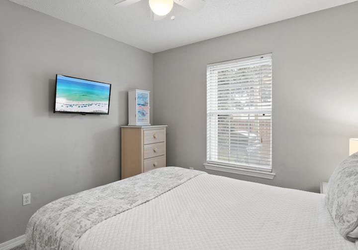 Chumba cha kulala cha wageni chenye mwanga na kitanda cha ukubwa wa kati, televisheni janja na mwanga wa asili, bora kwa ajili ya kupumzika baada ya siku nzima kwenye jua.