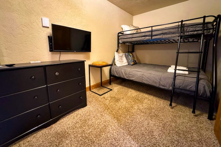 Долу в мазето, спалня №3 се радва на двуетажно легло с две единични легла и прикрепена полубаня, както и телевизор — идеален за деца!