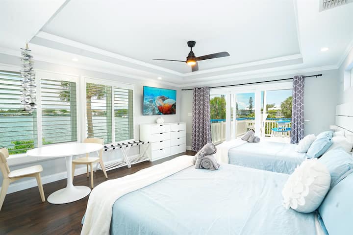 Chumba cha 5 cha kulala kinaangalia maji na kina vitanda viwili vya kifalme, televisheni mahiri na bafu la malazi.