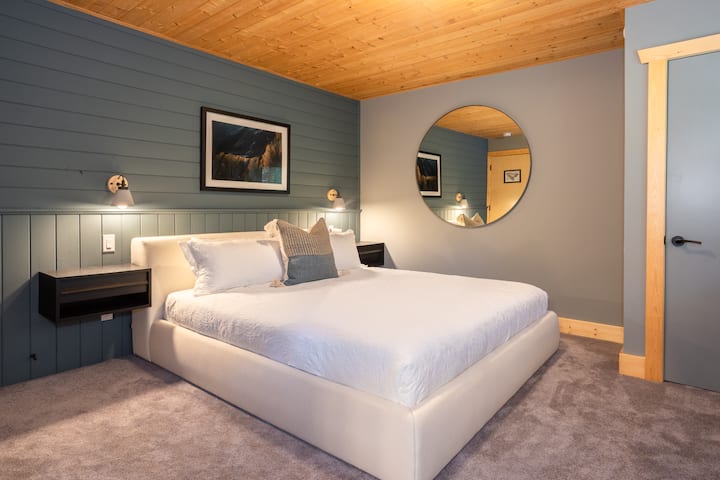 - ห้องนอนหรูหราพร้อมผนังสีน้ำเงินและการตกแต่งสไตล์มินิมอลสไตล์ภูเขา  
- กระจกวงกลมและแสงสว่างอ่อนช่วยสร้างความลึกและความผ่อนคลายที่สงบ  
- การออกแบบแบบอัลไพน์ที่ทันสมัยผสมผสานพื้นผิวไม้และความสบายที่เงียบสงบ  