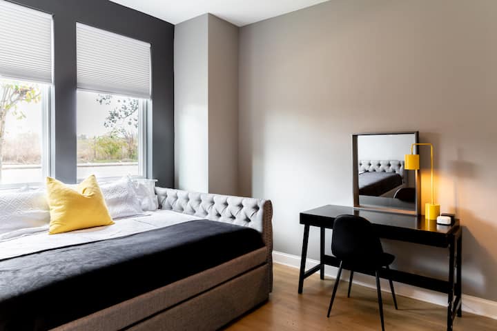 Спалня за гости на приземния етаж с двойно легло, двойно легло тип сандвич, работно пространство и телевизор. Пълна баня със самостоятелна баня, свързана с тази спалня.