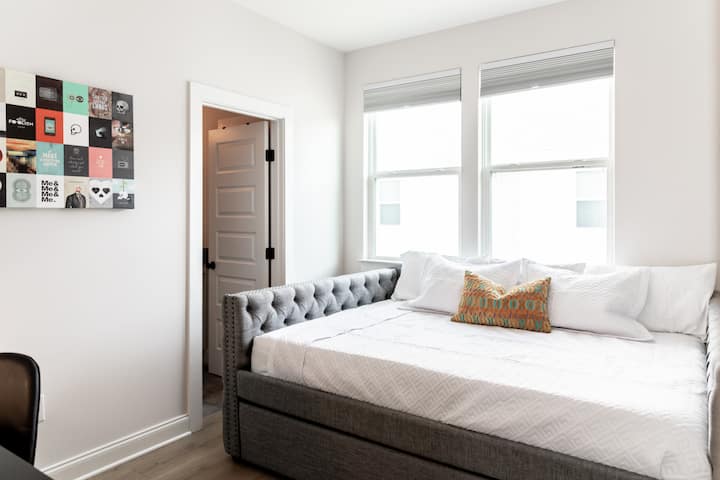 غرفة نوم للضيوف في الطابق العلوي بسرير بحجم ملكي وسرير متحرك مزدوج ومساحة عمل وتلفزيون. حمام داخلي كامل الحجم متصل بغرفة النوم هذه.