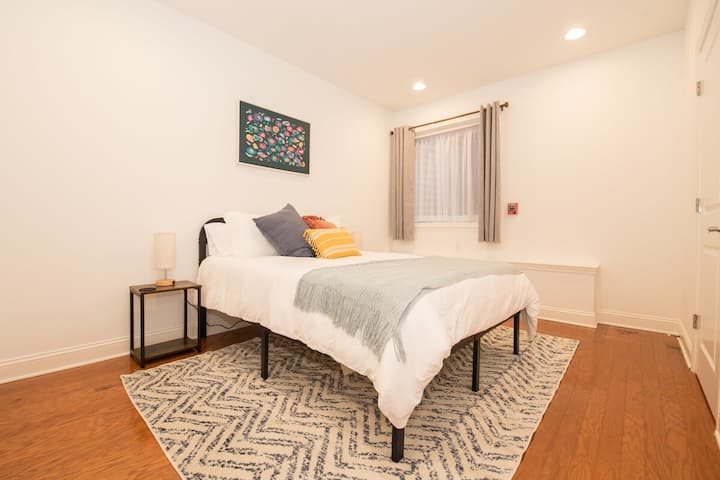 Štýlová spálňa s hlbokými námorníckymi závesmi, stropným ventilátorom a premyslenou výzdobou na pokojnú noc.