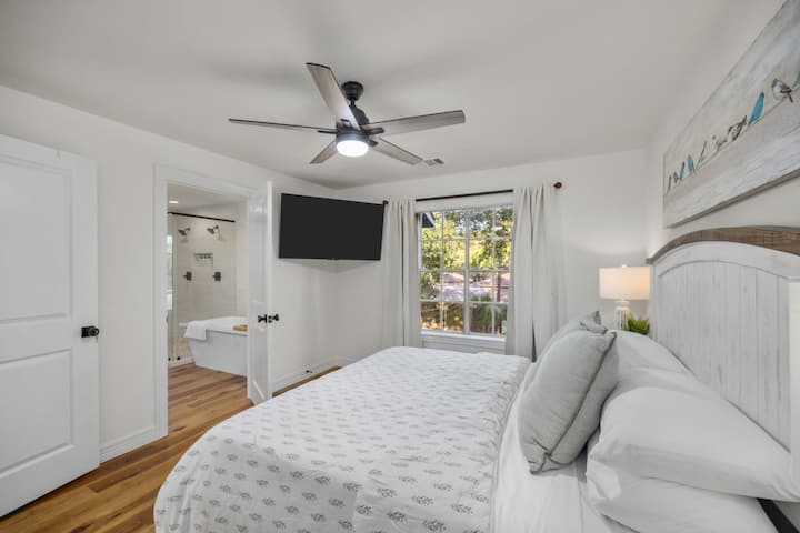 Alternate view of the primary bedroom with king bed, Smart TV, and en-suite bath.