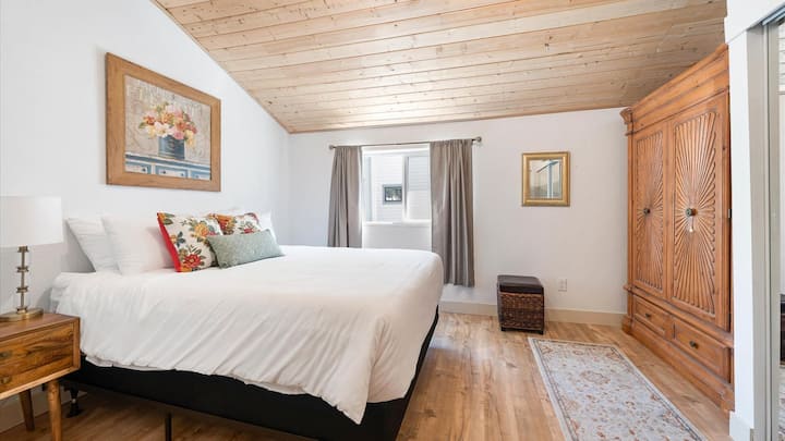 El dormitorio principal cuenta con techos abovedados, un lujoso colchón tamaño king, armario y amplio espacio en el armario. 