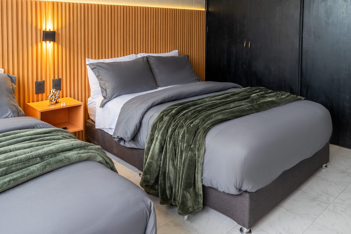 Dhomë gjumi elegante me dy krevate të rehatshëm.