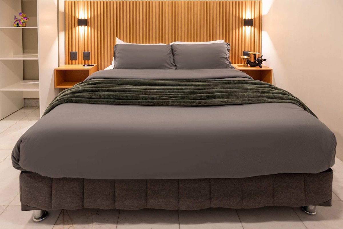 Relaksohu në stil me një krevat të gjerë me madhësi "Queen", shtroja të buta dhe ndriçim të ngrohtë për netët çlodhëse.