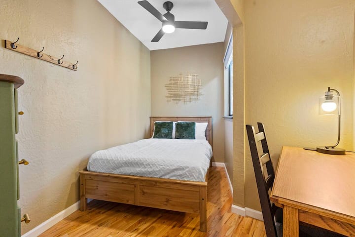 全尺寸床，楼上客房有一张小桌子。 