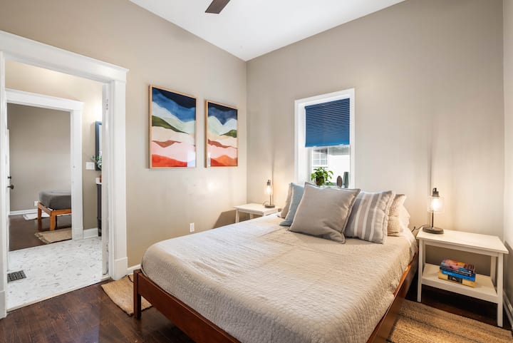 Modern queen bedroom featuring stylish artwork and simple comforts, ideal for relaxing during your KC stay.
