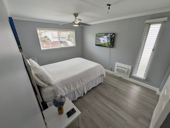 Chumba kikubwa chenye kitanda cha ukubwa wa malkia, televisheni iliyowekwa na mandhari ya milima 