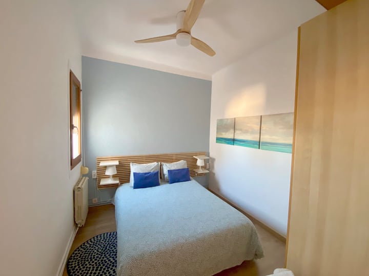 Freskuese dhe ftuese! Dhoma jonë dyshe me tematikë blu ka një ventilator tavani për rehati të shtuar. Kjo fotografi kap atmosferën dhe funksionalitetin e qetë, duke siguruar një qëndrim të këndshëm në apartamentin tonë në Barcelonë