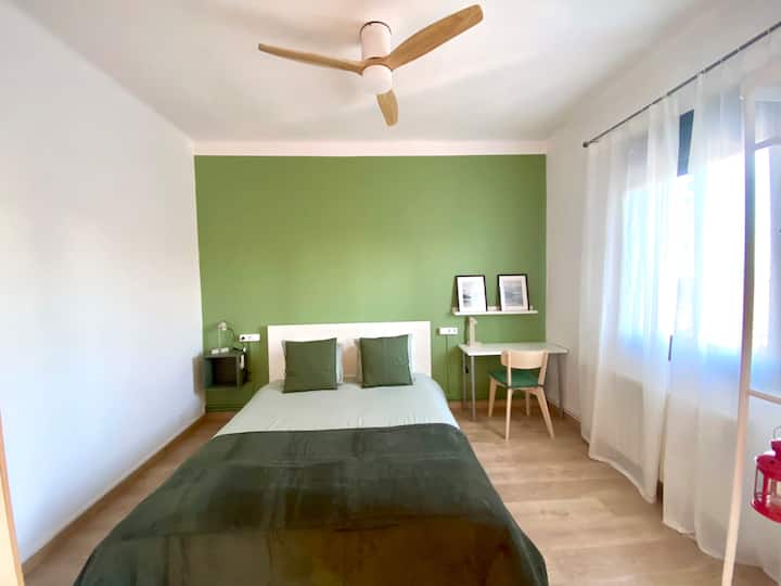 Qëndro i freskët dhe i rehatshëm në dhomën tonë të gjumit me tematikë jeshile me një krevat dopio "queen". Kjo fotografi shfaq ventilatorin elegant të tavanit, duke shtuar një ndjesi rehatie në ambientin e qetë të dhomës.