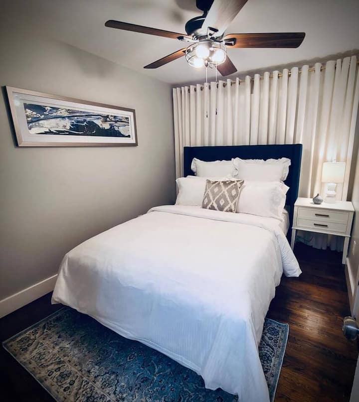 Cozy queen bedroom with fresh linens, soft lighting, and a comfortable setup for a restful night’s sleep.