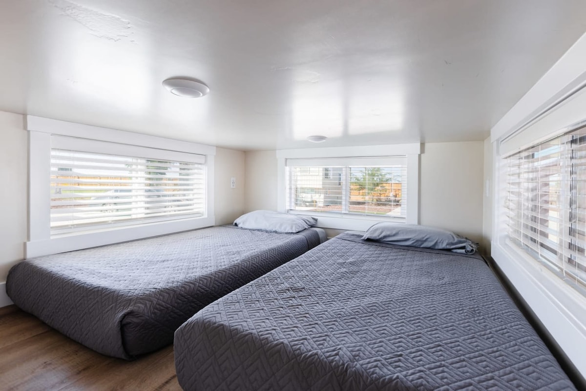 两张舒适的单人床，配有柔软清新的床上用品，让您享受一夜好眠。 这款毛绒床垫提供完美的支撑和舒适性，确保您醒来时感觉神清气爽，准备好迎接新的一天。