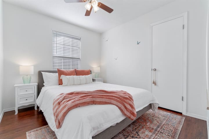 Moving onto bedroom number 2, fit with a queen sized bed, two bedside lamps perfect for reading and a beautiful subtle beach vibe surrounding you, with the soft colors and large beach wall art