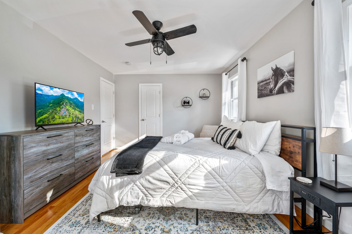 El mismo ambiente tranquilo: ropa de cama blanca, detalles en madera oscura y TV con vista a la montaña. Las obras de arte de caballos y los textiles suaves agregan calidez. Amplio espacio, pisos de madera y ventanas ventiladas crean un santuario tranquilo perfecto para relajarse.