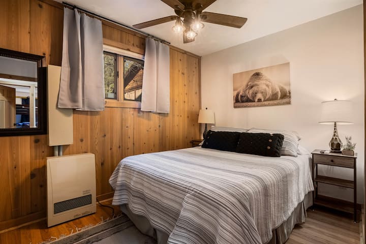 يضيف هذا الجدار الخشبي الطبيعي إحساسًا إلى بقعة السبات الرائعة هذه مع سرير كوين