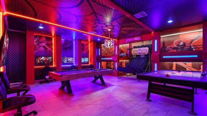 Epic Spider-Man game room with pool table, dual gaming setups, and neon vibre.