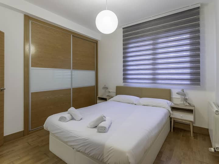 Habitación principal con una cómoda cama doble, con una mesa de noche en cada lado de la misma y con un gran espacio de almacenaje. 
