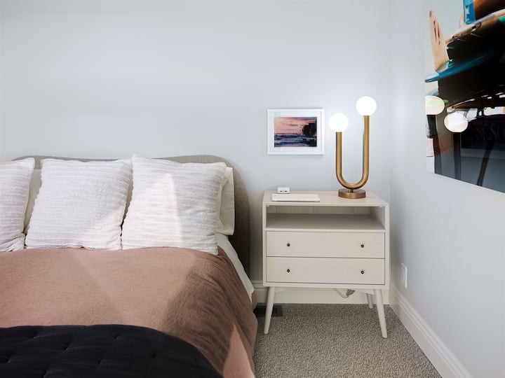 Third bedroom features a queen sized bed and has charging stations on nightstands