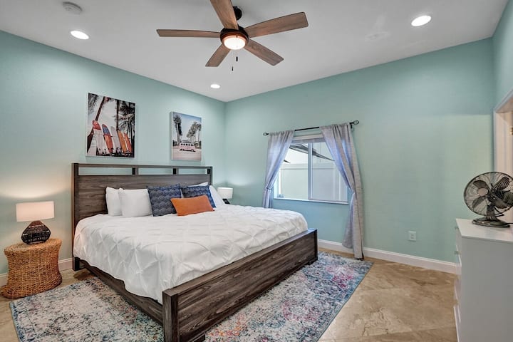 Habitación principal en la planta baja con una cama tamaño king, colores costeros y un encanto acogedor. Perfecto para noches de descanso después de la aventura del día, con fácil acceso al resto de la casa para mayor comodidad y conveniencia.