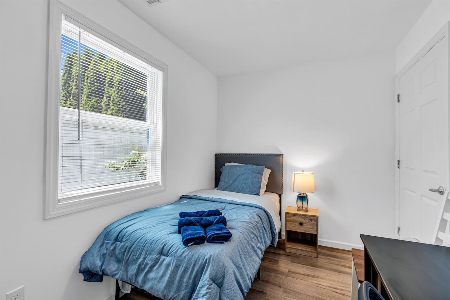 Settle into the quiet second bedroom for whoever drew the short straw. Twin bed, blinds you can drop early, blackout-quiet street.