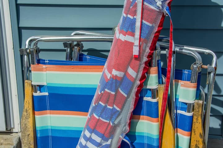 Grab the vintage beach chairs and striped umbrella on your way out the door. They stay with the house, no rental-stand line.