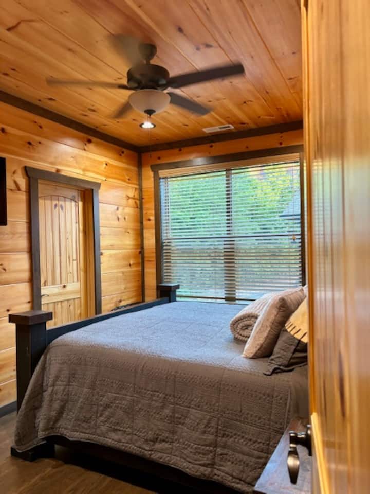 Горно ниво на спалня с суперголямо двойно легло, баня и телевизор.