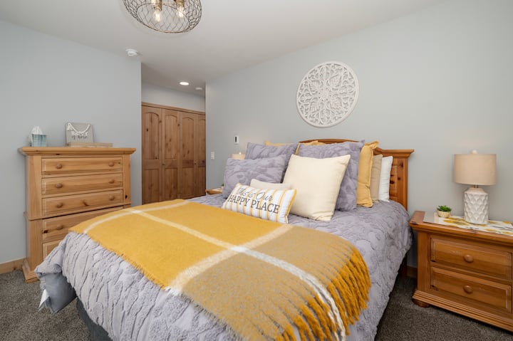 გაიძინეთ ამ მყუდრო საძინებელში, სადაც რბილი ნაცრისფერი თეთრეული შეხვდება თბილ ყვითელ აკცენტებს, რაც იდეალურ გარემოს ქმნის დასასვენებლად.