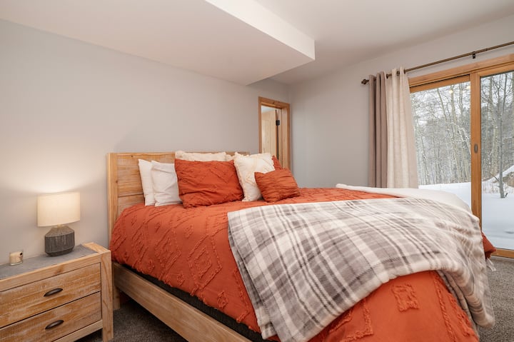 გაიღვიძეთ ამ მყუდრო საძინებელში, რომელიც გათბობილია თბილი ნარინჯისფერი თეთრეულით, ხოლო დიდი ფანჯრებიდან ზამთრის ტყის წყნარი ხედი იშლება.