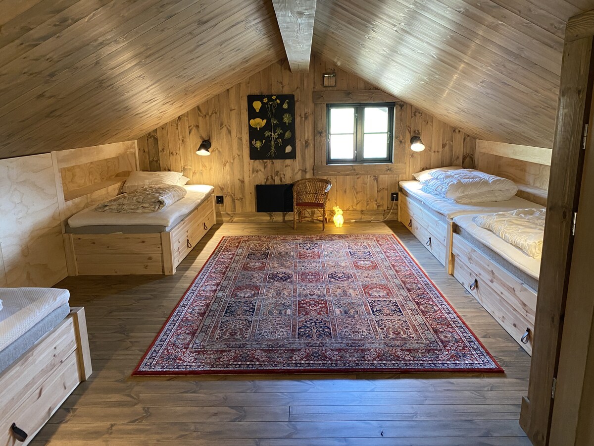 Útulná spálňa s dreveným interiérom, mäkkým osvetlením a pohodlnou posteľou.