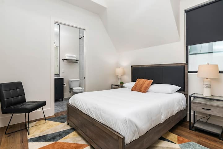 Habitación queen con baño privado con cortinas que oscurecen la habitación