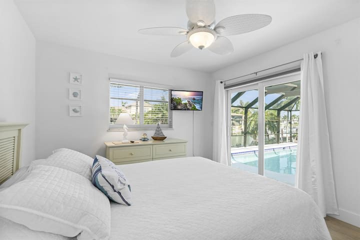 Relax in the Second Bedroom with Convenient Pool Access and Captivating Views of the Tranquil Canal.