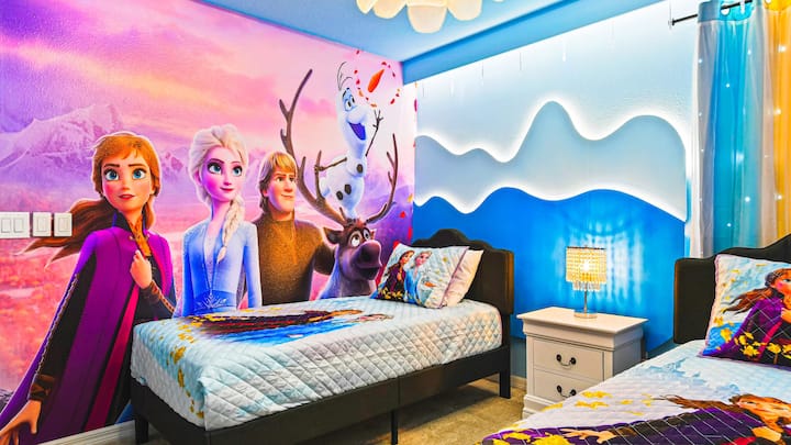 Förtrollande rum med Frozen-tema, isig inredning, mysiga sängar och glittrande lampor.