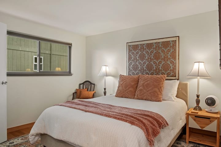 მე-2 საძინებელი Queen Bear-ის ჰიბრიდული მატრასით, ჟალუზებით, საწოლთან მდგარი მაგიდებით და მბრუნავი ვენტილატორით.  