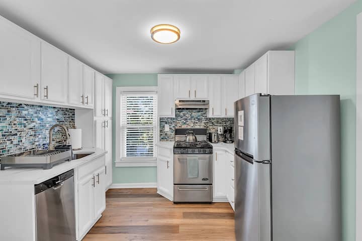 Cook in style at The Embury Retreat's fully equipped kitchen. Modern appliances, ocean-inspired backsplash, and ample space for preparing Jersey Shore favorites. Steps from Ocean Grove beach and Asbury Park dining
