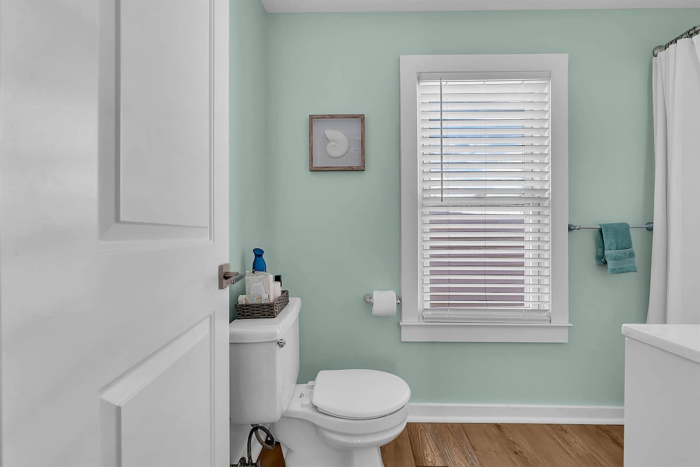 Enjoy a clean, modern bathroom with soft coastal hues, a full shower, and simple touches designed for comfort and convenience.