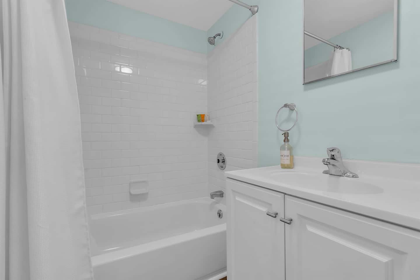 Enjoy a clean, modern bathroom with soft coastal hues, a full shower, and simple touches designed for comfort and convenience.