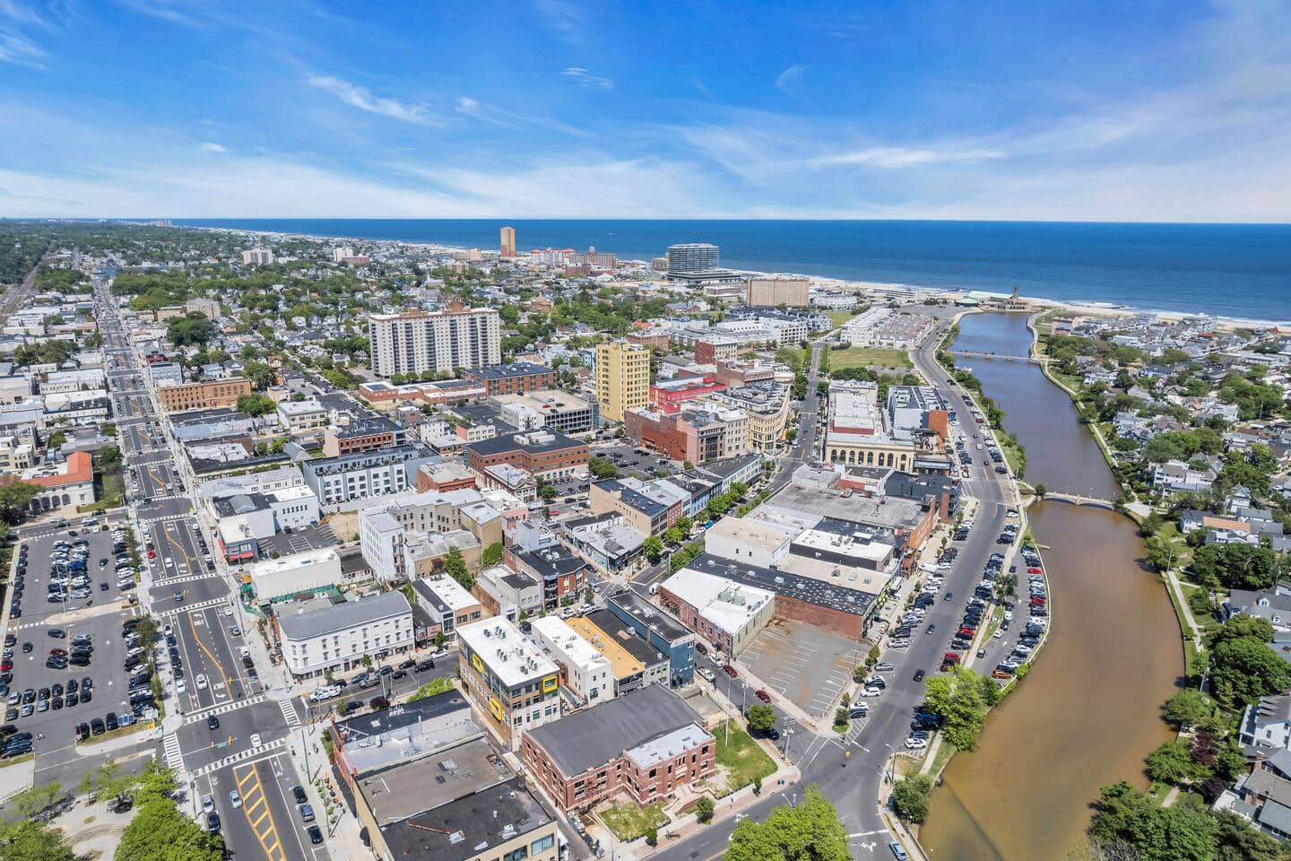 Wide aerial view over Asbury Park's downtown, the inlet and the ocean beyond