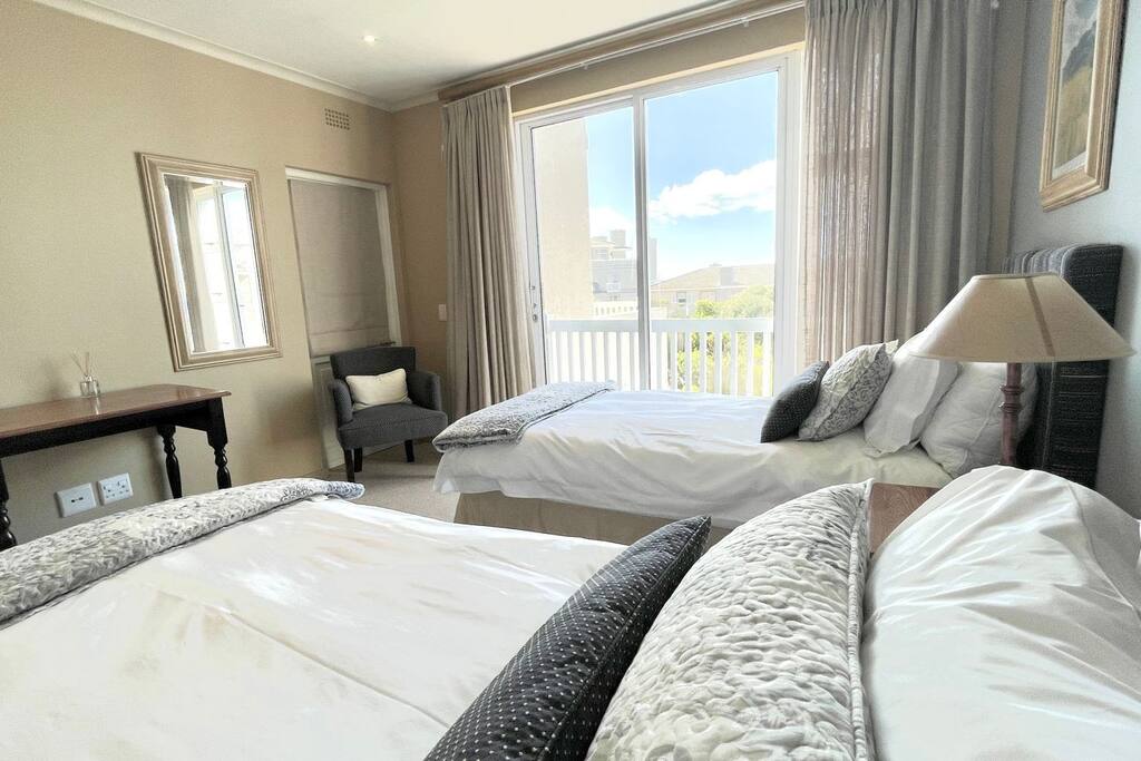 Удобна спална соба со два единечни кревета и прекрасен поглед кон океанот