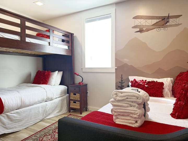 Chambre avec des lits superposés et des oreillers rouges.