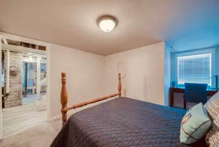 غرفة نوم مع سرير كامل ومنطقة عمل وتلفزيون وخزانة ملابس