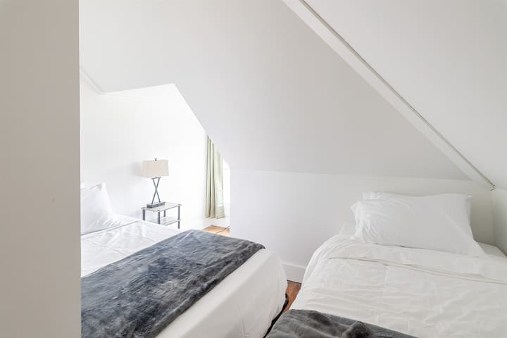 Idéale pour le partage, cette chambre au troisième étage avec deux lits offre beaucoup de confort et d'espace pour les invités ou les frères et sœurs.