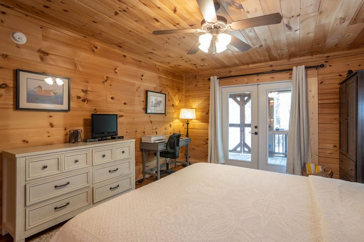Chambre principale avec télévision et espace de bureau