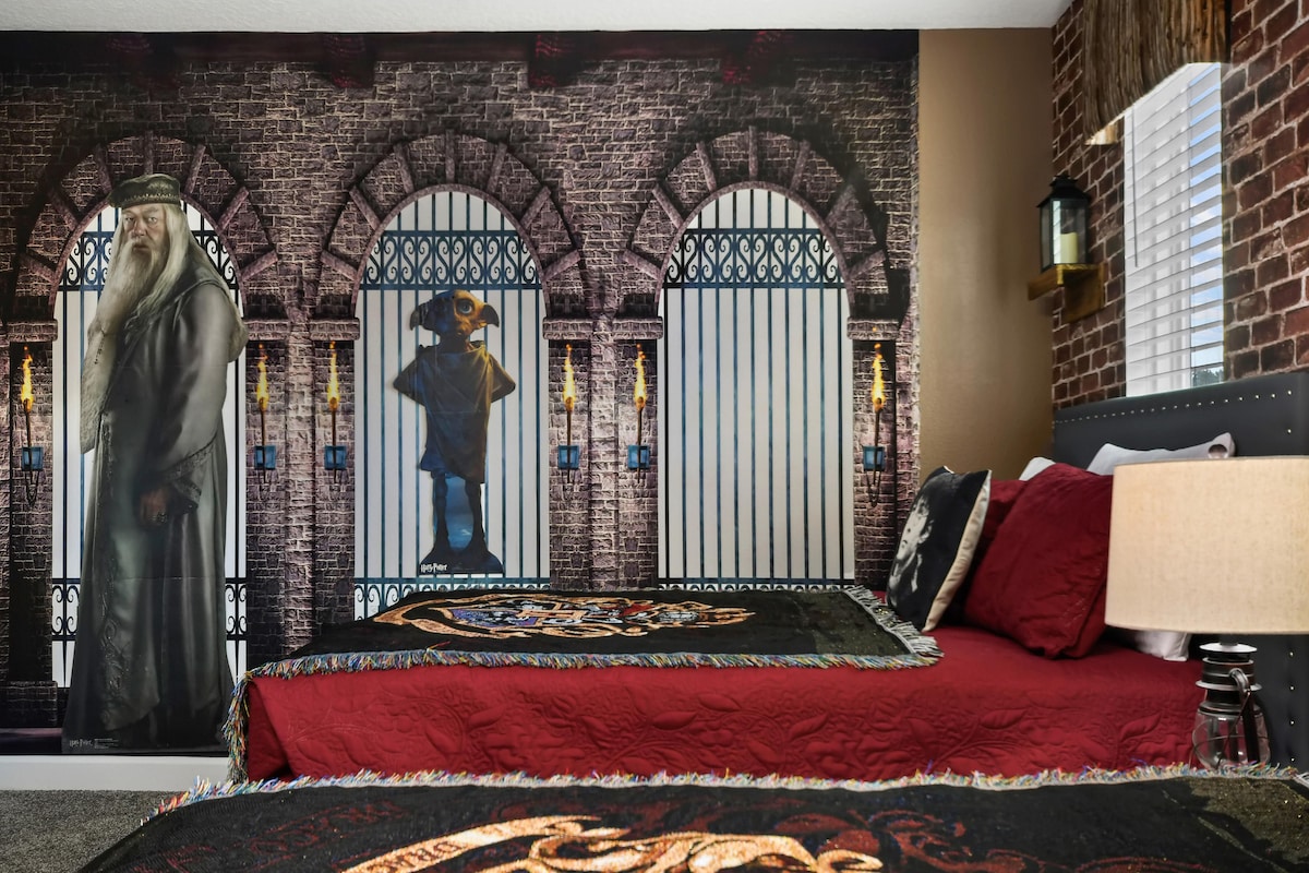 ห้องนอนธีมวิซาร์ดสุดมหัศจรรย์พร้อมเตียงนอนสบายๆ 3 หลังผนังอิฐและการตกแต่งที่มีมนต์เสน่ห์